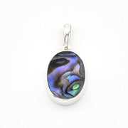 An oval pendant featuring a polished iridescent abalone shell inlay with blue, purple, green, and black swirls, set in a silver-toned metal bezel with a silver bail, shown on a plain white background.