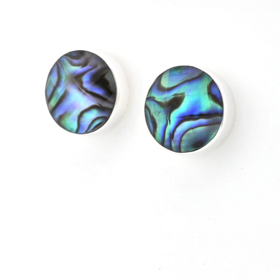 A pair of round stud earrings with iridescent abalone shell inlays on a white background.
