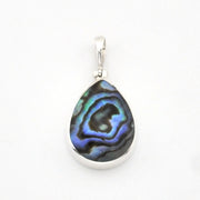 A teardrop-shaped pendant featuring a polished iridescent abalone shell inlay with blue, green, and black swirls, set in a silver-toned metal bezel with a silver bail, shown on a plain white background.