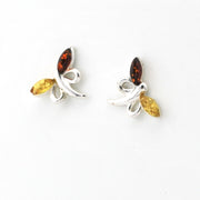 A pair of silver butterfly stud earrings featuring marquise-cut amber brown top stones and yellow bottom stones, set against a plain white background.