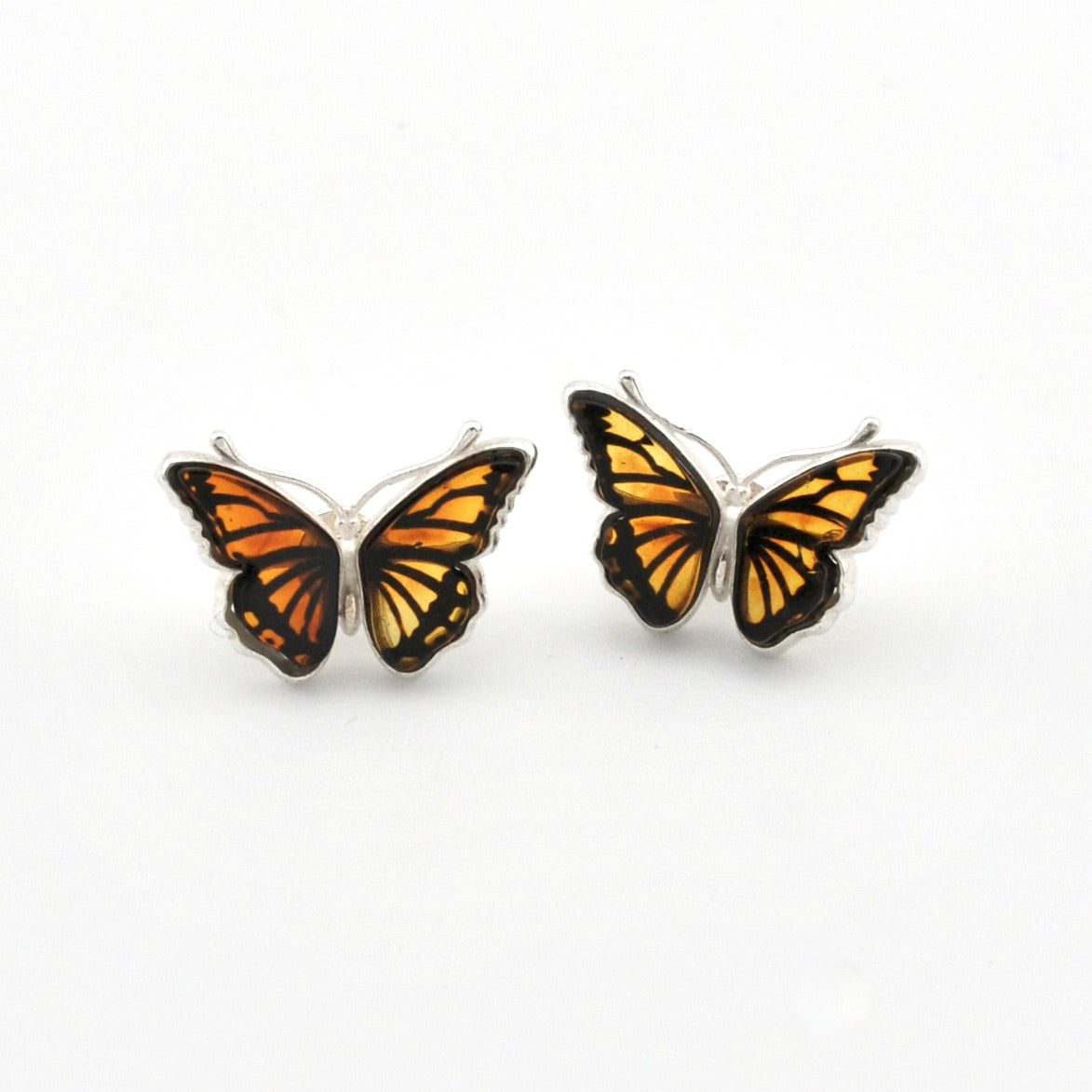 A pair of butterfly-shaped stud earrings with orange and black patterned wings and silver-toned metal borders, shown on a plain white background.