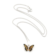 A silver chain necklace featuring a butterfly pendant with orange and black wings, displayed on a clean white background.