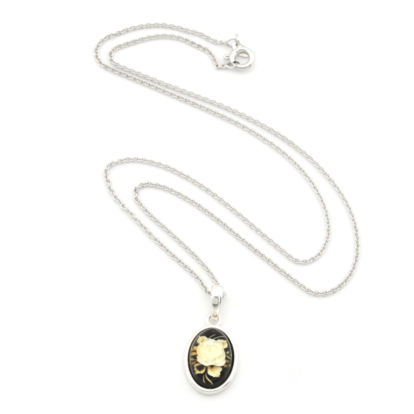 A silver chain necklace with an oval pendant featuring a black background and a vintage-style illustration of a yellow flower in a silver frame, displayed on a clean white background.