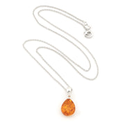 A silver chain necklace with a teardrop-shaped amber pendant, displayed on a clean white background.