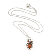 A silver owl pendant necklace featuring a polished amber-orange center stone and two smaller amber stones for eyes, displayed on a clean white background.