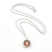 A silver tree of life pendant necklace with amber-colored inlay, displayed on a clean white background.