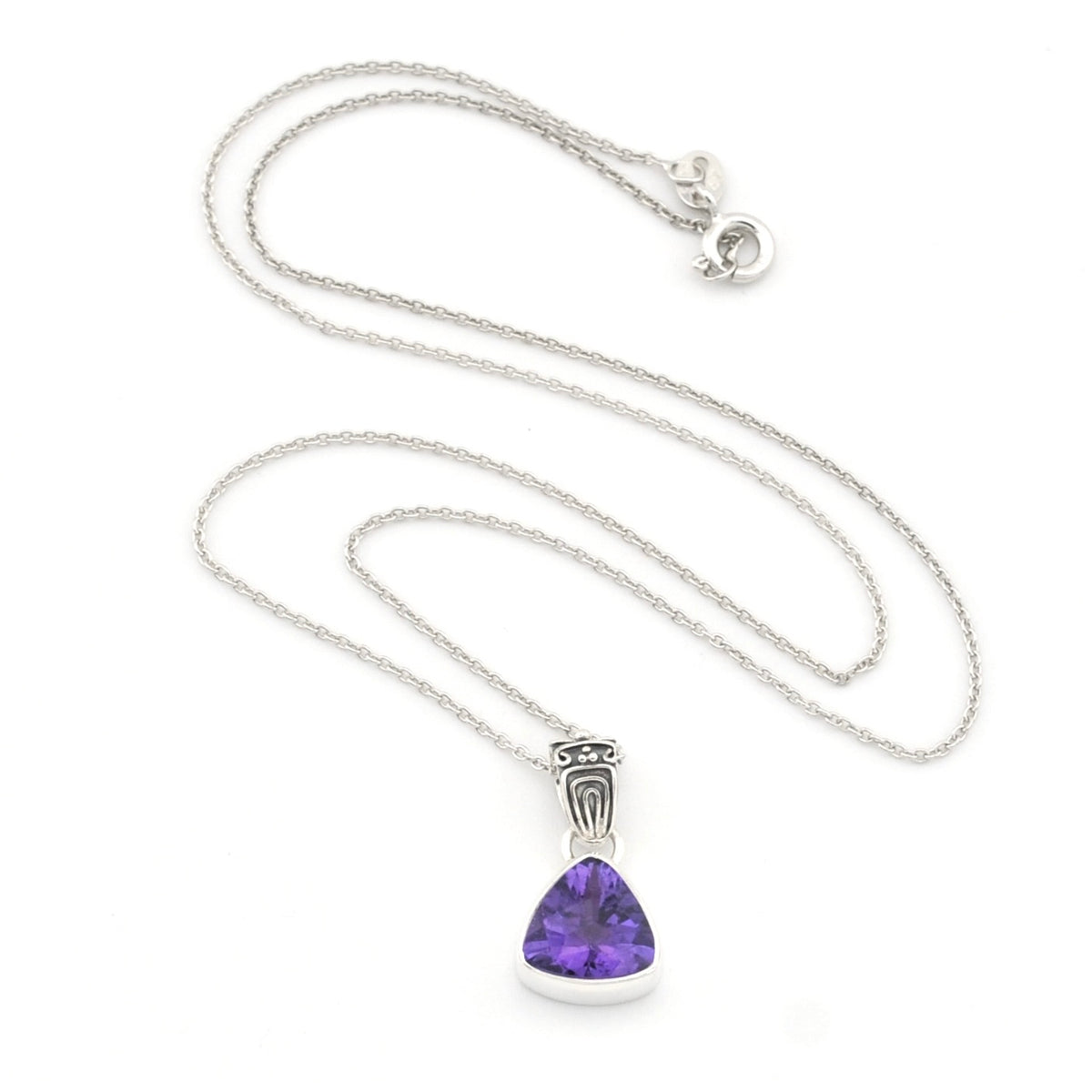A silver chain necklace with a triangular bezel-set purple crystal pendant, displayed on a clean white background.
