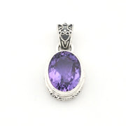 An oval-cut purple amethyst pendant in a silver-toned bezel setting with an ornate decorative bail, shown against a plain white background.