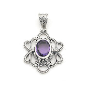 A silver filigree pendant featuring an oval purple amethyst gemstone in the center, set against a plain white background.