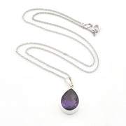A silver teardrop pendant necklace featuring a faceted purple gemstone, displayed on a clean white background.