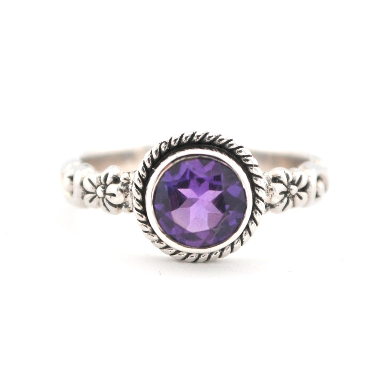 Silver ring with a purple gemstone on a white background