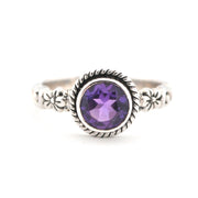 Silver ring with a purple gemstone on a white background