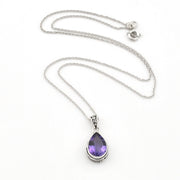 A silver chain necklace with a teardrop-shaped purple gemstone pendant, displayed on a clean white background.