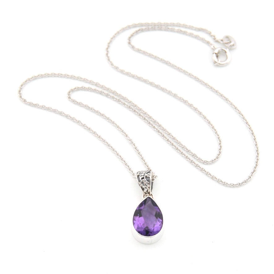 A silver teardrop pendant necklace with a faceted purple gemstone, displayed on a clean white background.