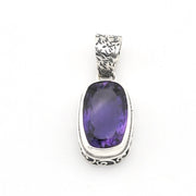 A sterling silver pendant featuring a large, bezel-set oval purple amethyst gemstone, with an engraved textured bail at the top, shown on a plain white background.