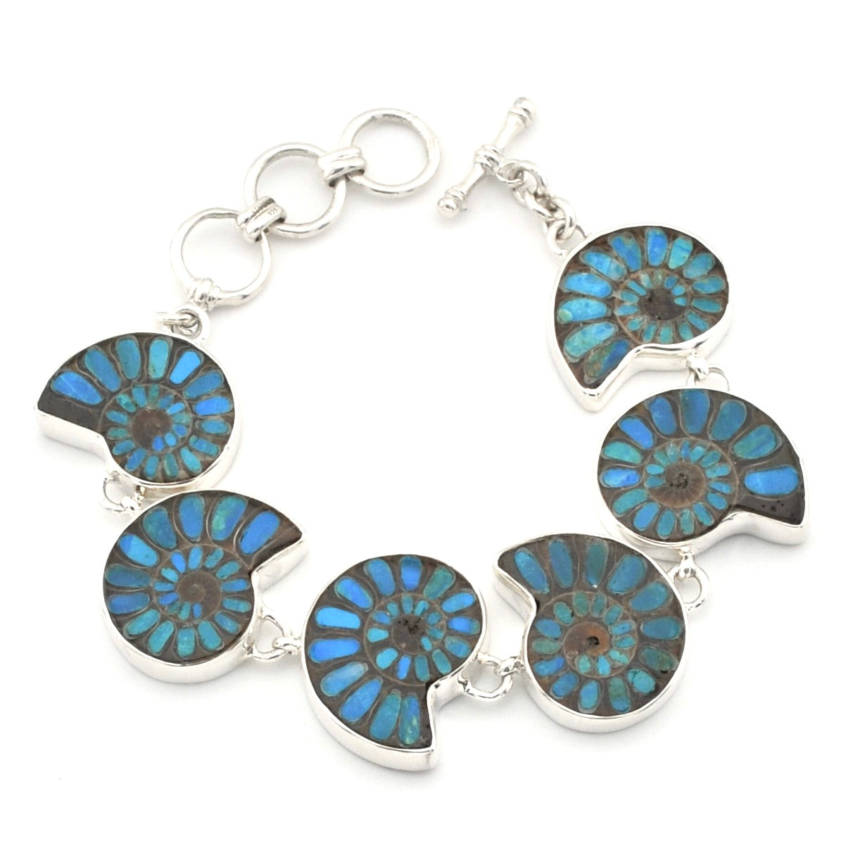 A silver-toned bracelet featuring six round ammolite shell inlays with vibrant blue and green iridescent patterns, set in polished silver on a white background.