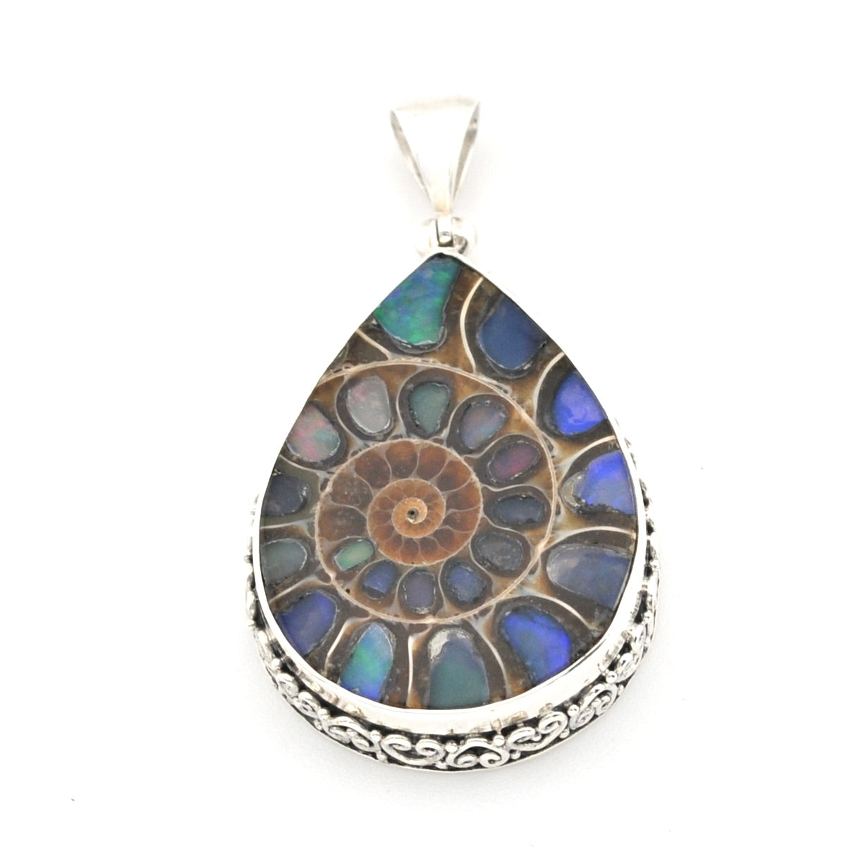 A teardrop-shaped silver pendant featuring a detailed mosaic of blue, green, and brown opal-like stones in a spiral pattern, set in a silver frame with a decorative border and a silver bail, shown on a plain white background.
