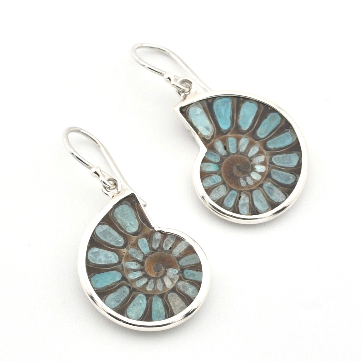 A pair of silver leverback earrings featuring spiral ammonite shell inlays with light blue and brown natural stone patterns, shown on a plain white background.
