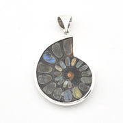A teardrop-shaped silver pendant featuring a polished mosaic of natural ammolite stones in shades of gray, blue, green, and a small orange center, suspended on a white background.
