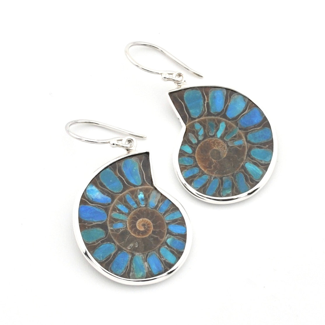 A pair of teardrop-shaped dangle earrings featuring natural ammolite with a spiral fossil pattern in shades of blue, brown, and gray, set in polished silver-tone metal with fishhook wires.