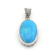 An oval pendant featuring a vibrant blue turquoise stone set in an ornate, textured sterling silver frame with a decorative bail.
