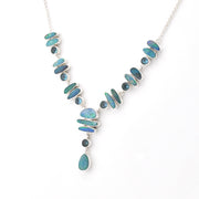 A silver Y-shaped necklace featuring inlaid blue-green opal stones of various shapes and sizes, with a teardrop-shaped opal drop pendant, shown on a plain white background.