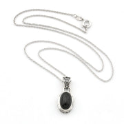 A sterling silver chain necklace with an oval pendant featuring a black cabochon stone in a silver bezel setting, displayed on a clean white background.