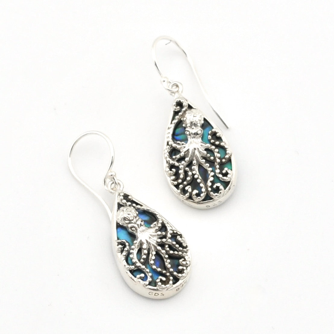 A pair of silver teardrop dangle earrings featuring intricate filigree octopus designs and iridescent blue-green abalone shell inlays, set against a plain white background.