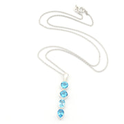 A silver chain necklace featuring a vertical drop pendant with four light blue gemstones in bezel settings, displayed on a clean white background.
