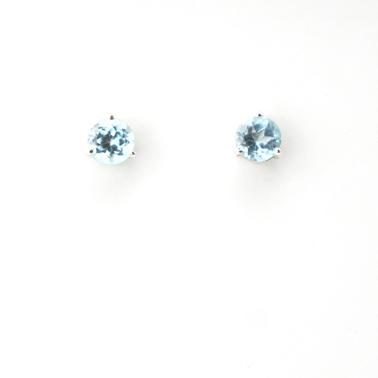 Pair of round blue gemstone earrings on a white background