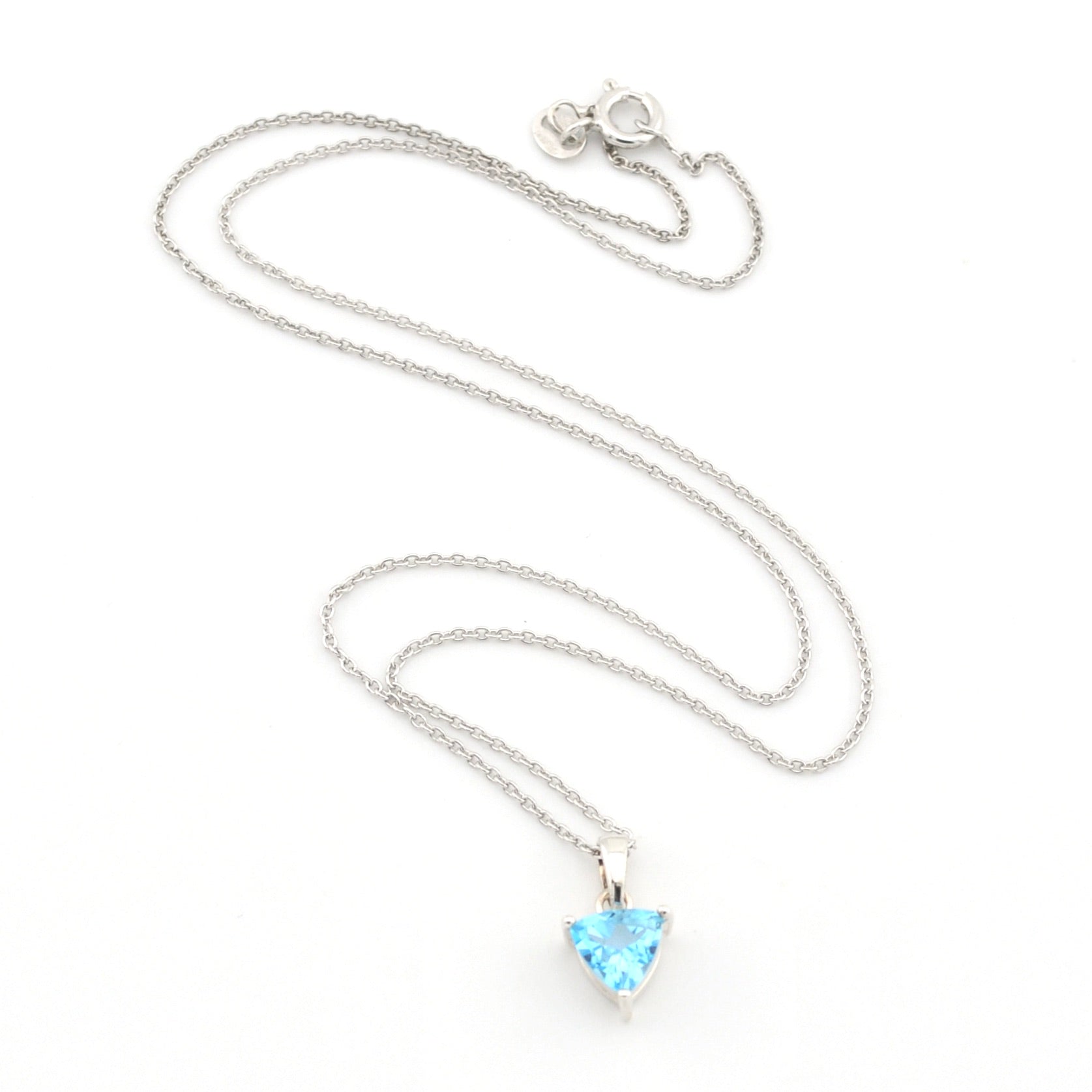 A silver chain necklace with a small trillion-shaped light blue gemstone pendant, displayed on a clean white background.