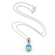 A silver chain necklace with an oval bezel setting holding a light blue gemstone, displayed on a clean white background.