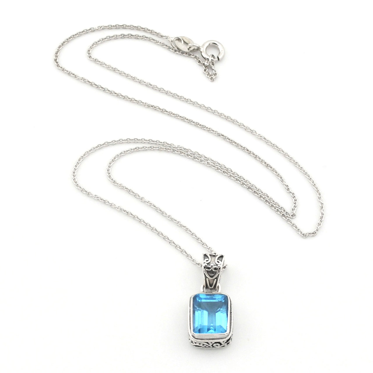 A silver-toned necklace featuring a rectangular light blue gemstone pendant with a decorative silver bail, displayed on a clean white background.