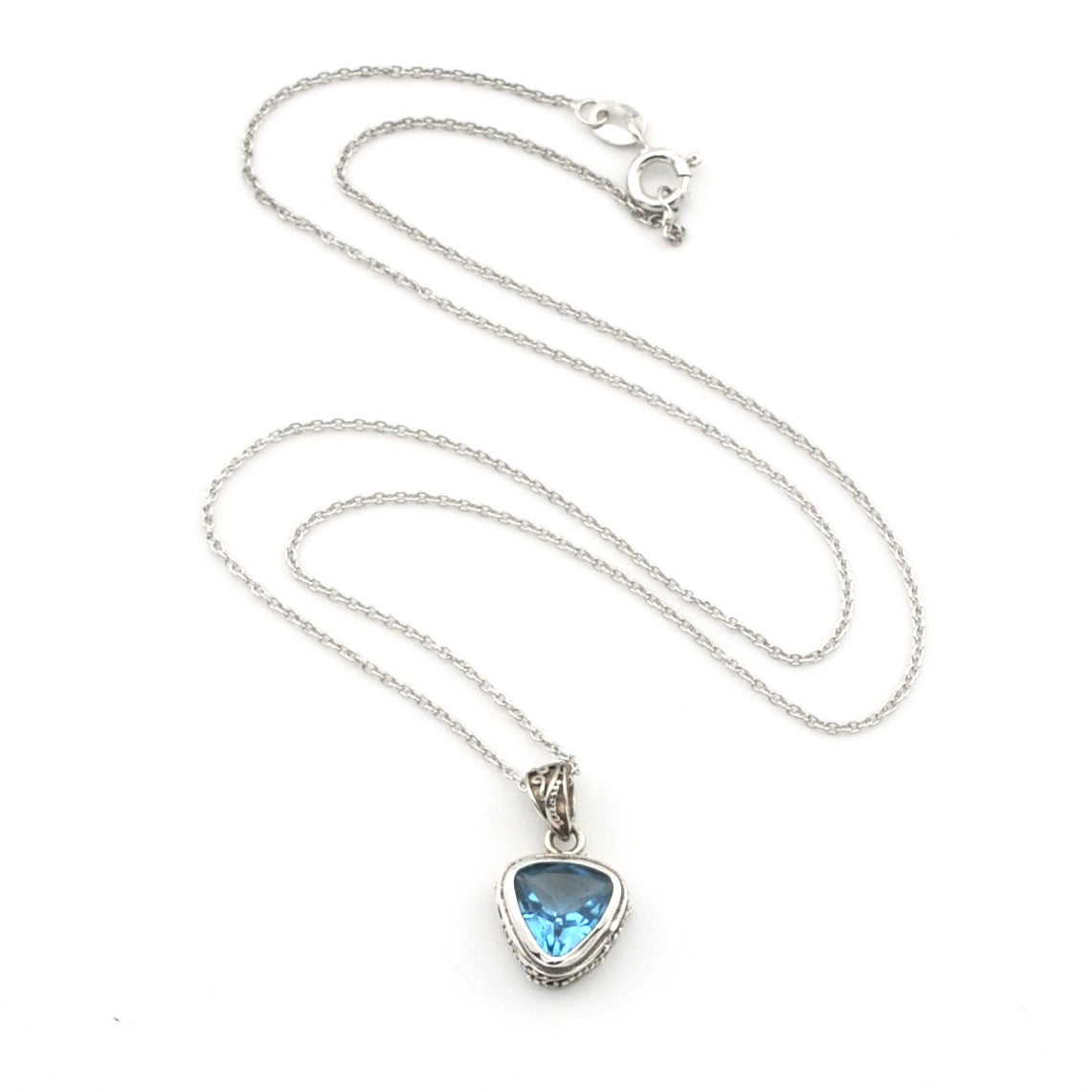A silver chain necklace with a trillion-shaped pendant featuring a light blue gemstone, displayed on a clean white background.