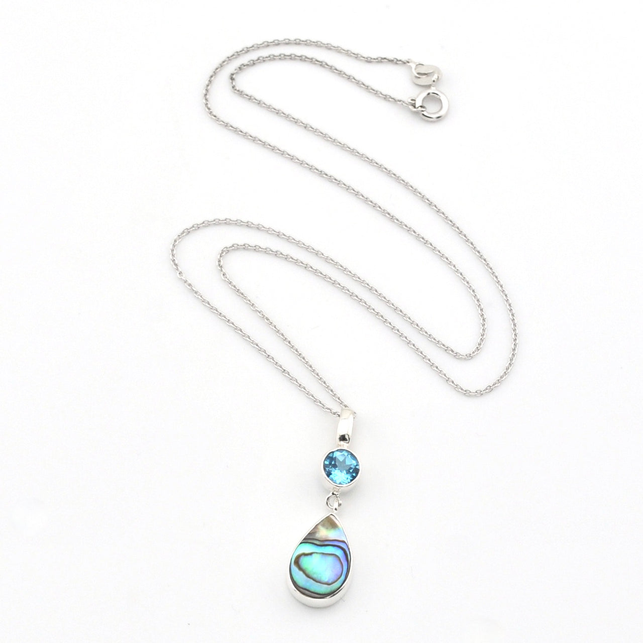 A silver necklace featuring a teardrop-shaped abalone shell pendant and a small round blue gemstone, displayed on a clean white background.