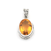 An oval-cut orange gemstone pendant set in a silver-toned bezel with a decorative bail, shown on a plain white background.