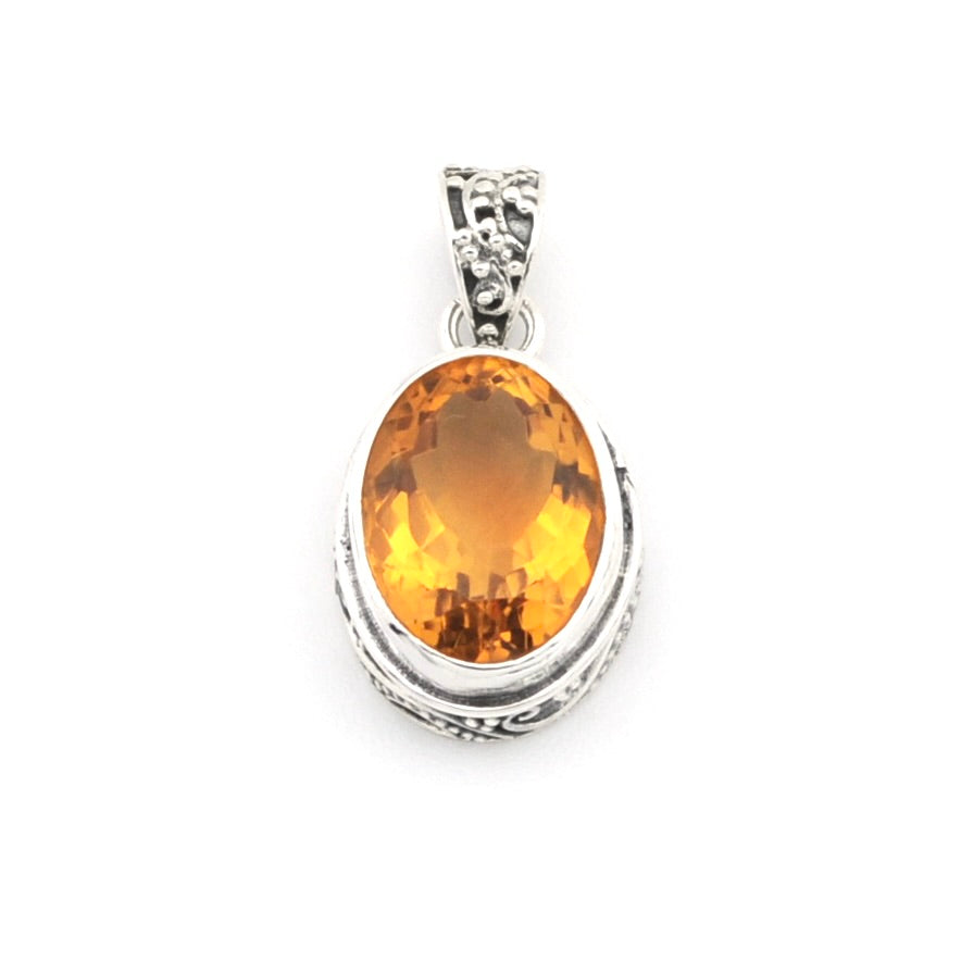 An oval-cut orange gemstone pendant set in a silver-toned bezel with a decorative bail, shown on a plain white background.