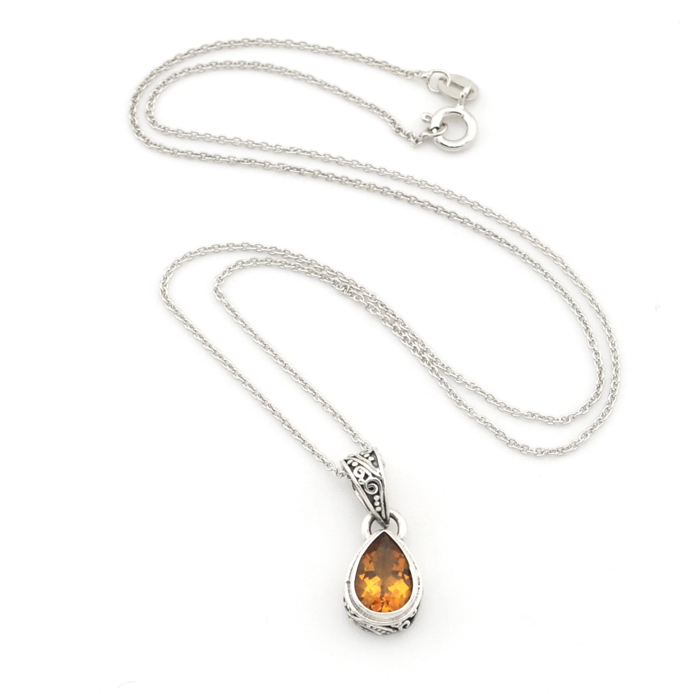 A silver teardrop pendant necklace featuring a warm citrine gemstone, displayed on a clean white background.