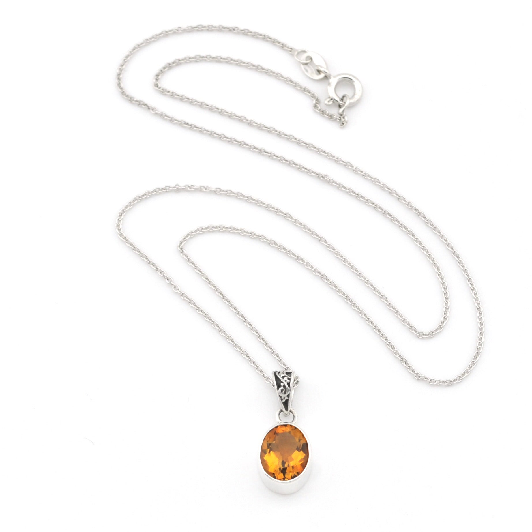 A silver chain necklace with an oval amber-orange gemstone pendant in a silver bezel setting, displayed on a clean white background.
