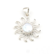Silver sun-shaped pendant with a central gemstone on a white background