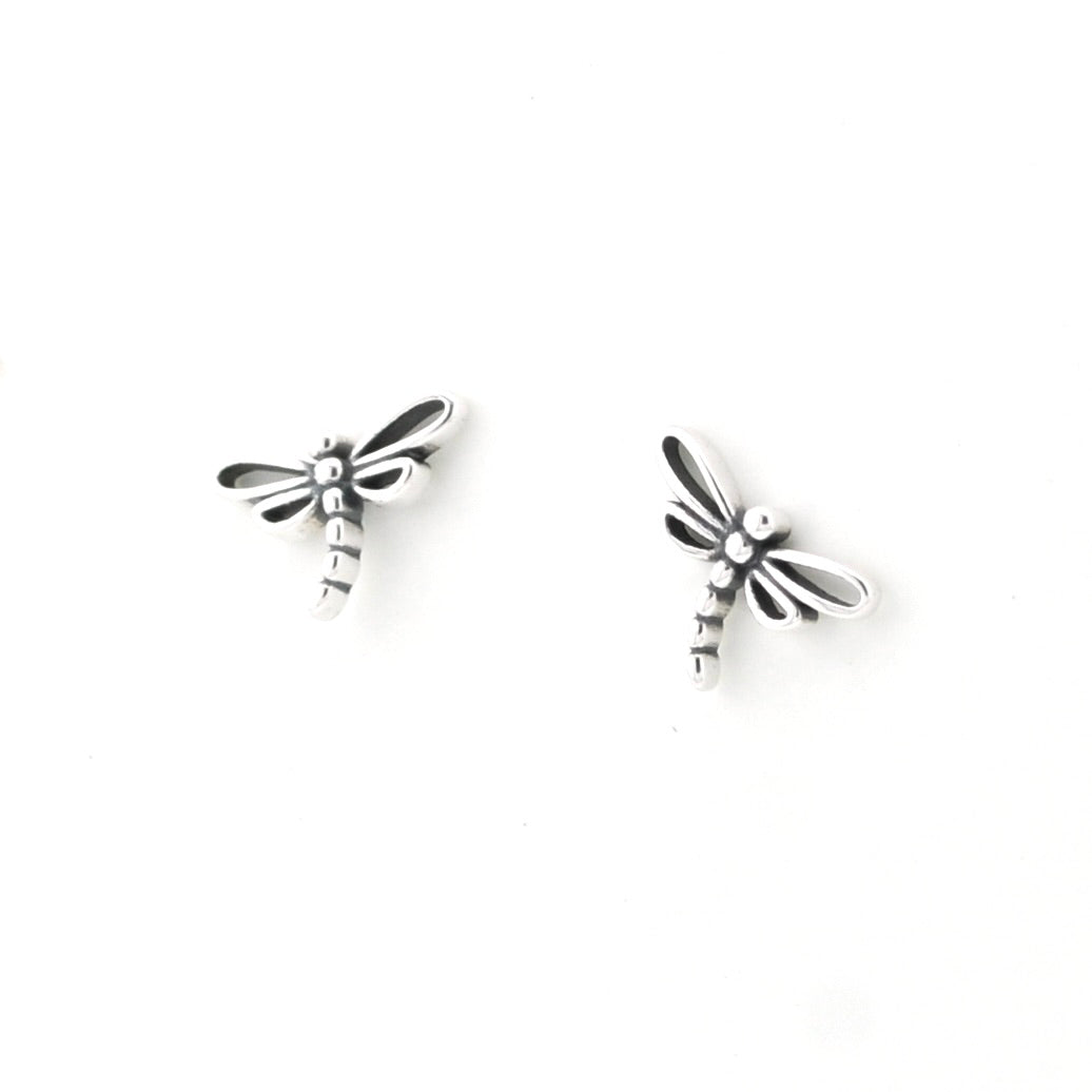 A pair of silver dragonfly stud earrings on a plain white background.