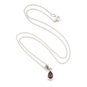 A silver chain necklace with a teardrop-shaped dark red gemstone pendant, displayed on a clean white background.