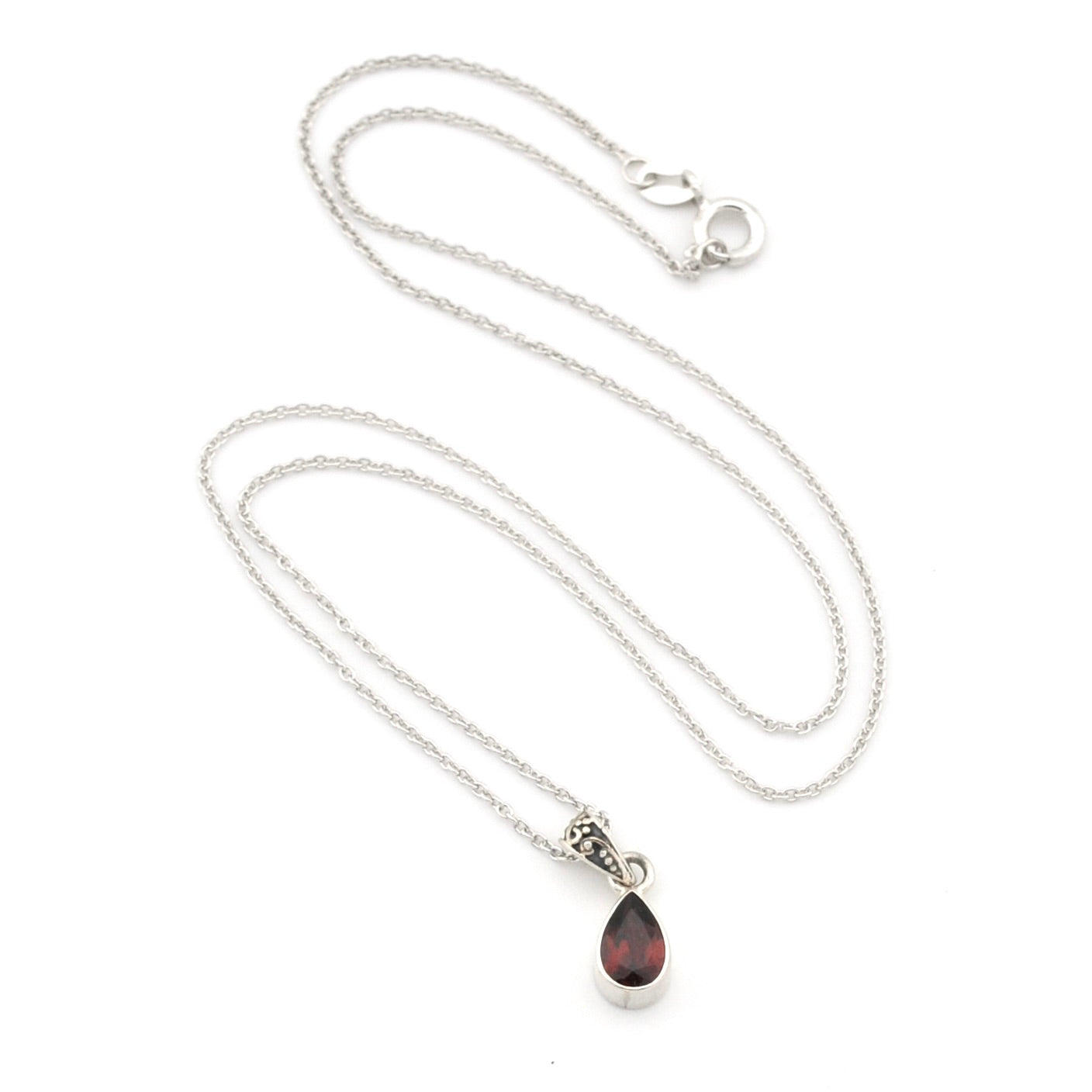 A silver chain necklace with a teardrop-shaped dark red gemstone pendant, displayed on a clean white background.
