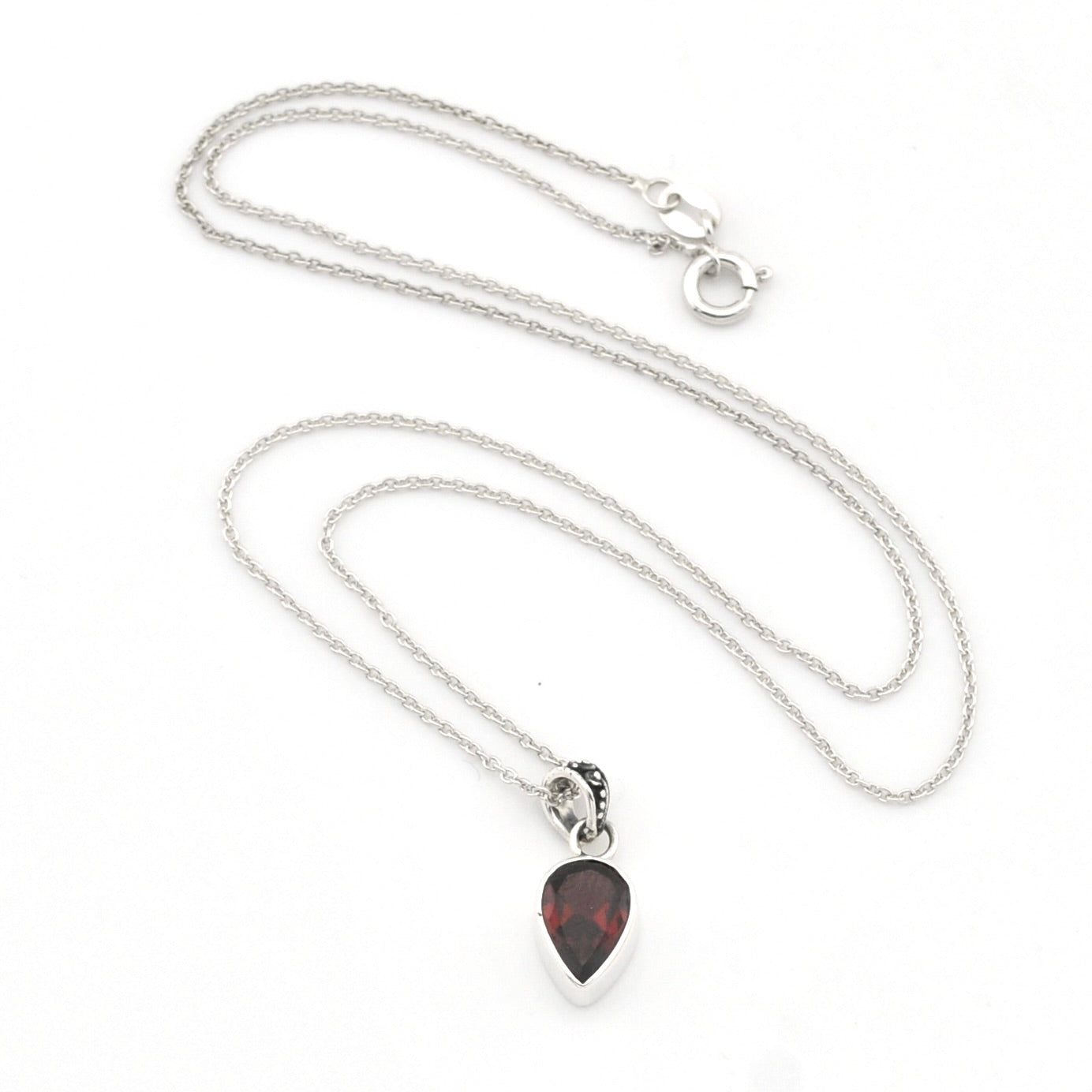 A silver chain necklace with a teardrop-shaped pendant featuring a dark red, marbled gemstone in a silver bezel setting, displayed on a clean white background.