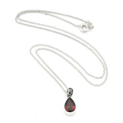 A silver chain necklace with a teardrop-shaped dark red gemstone pendant, displayed on a clean white background.