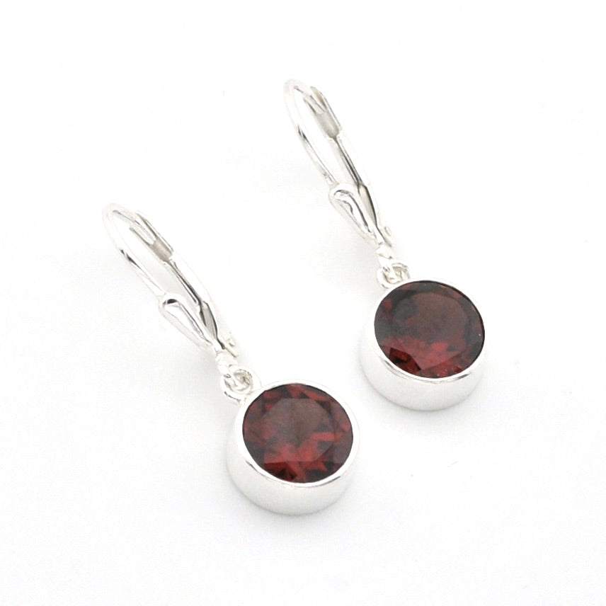 A pair of silver leverback earrings with round dark red garnet gemstones, shown on a clean white background.