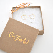 Gold hoop earrings in a 'Be Jeweled' box on a white background