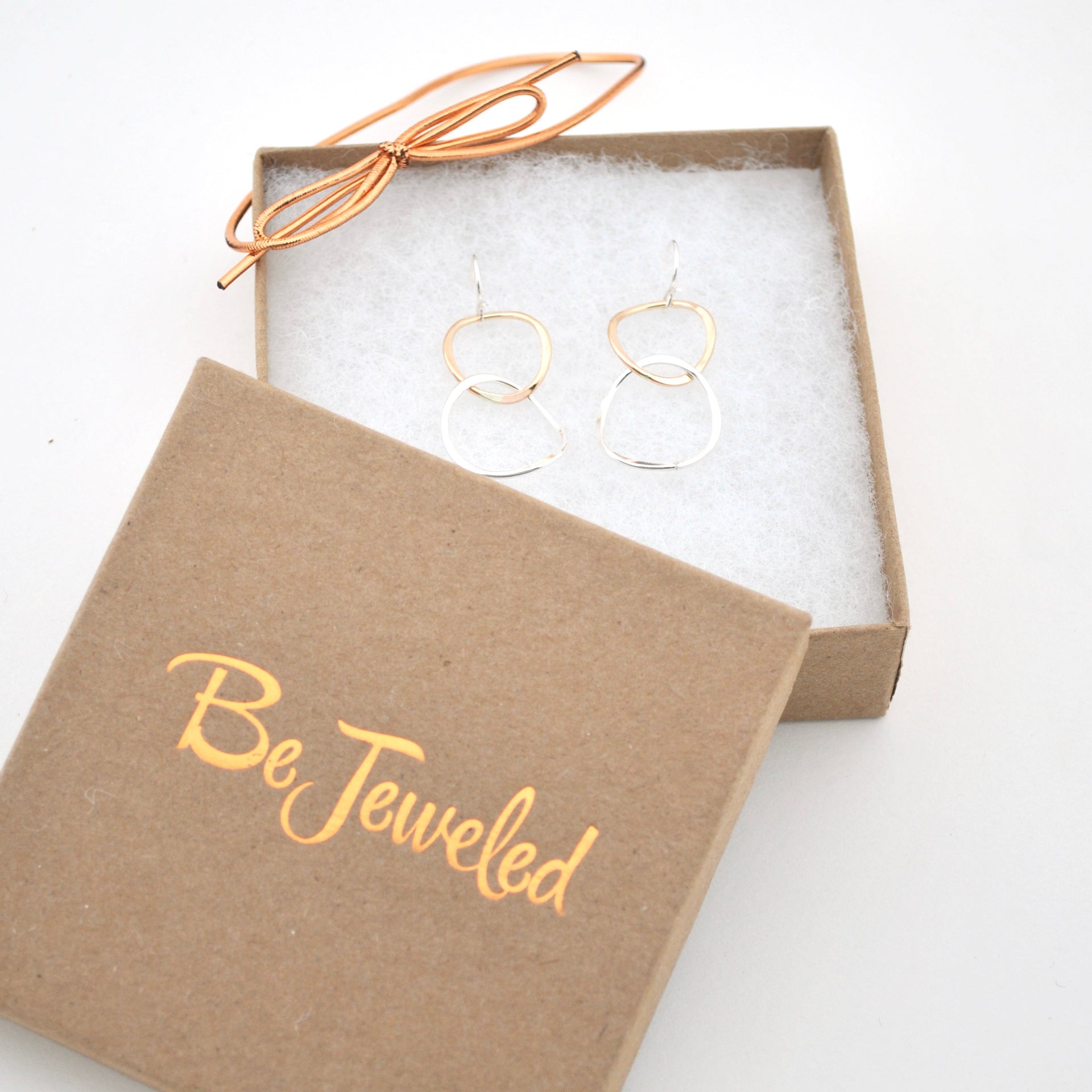 Gold hoop earrings in a 'Be Jeweled' box on a white background