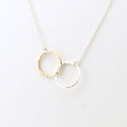 Necklace with interlocking gold and silver rings on a white background