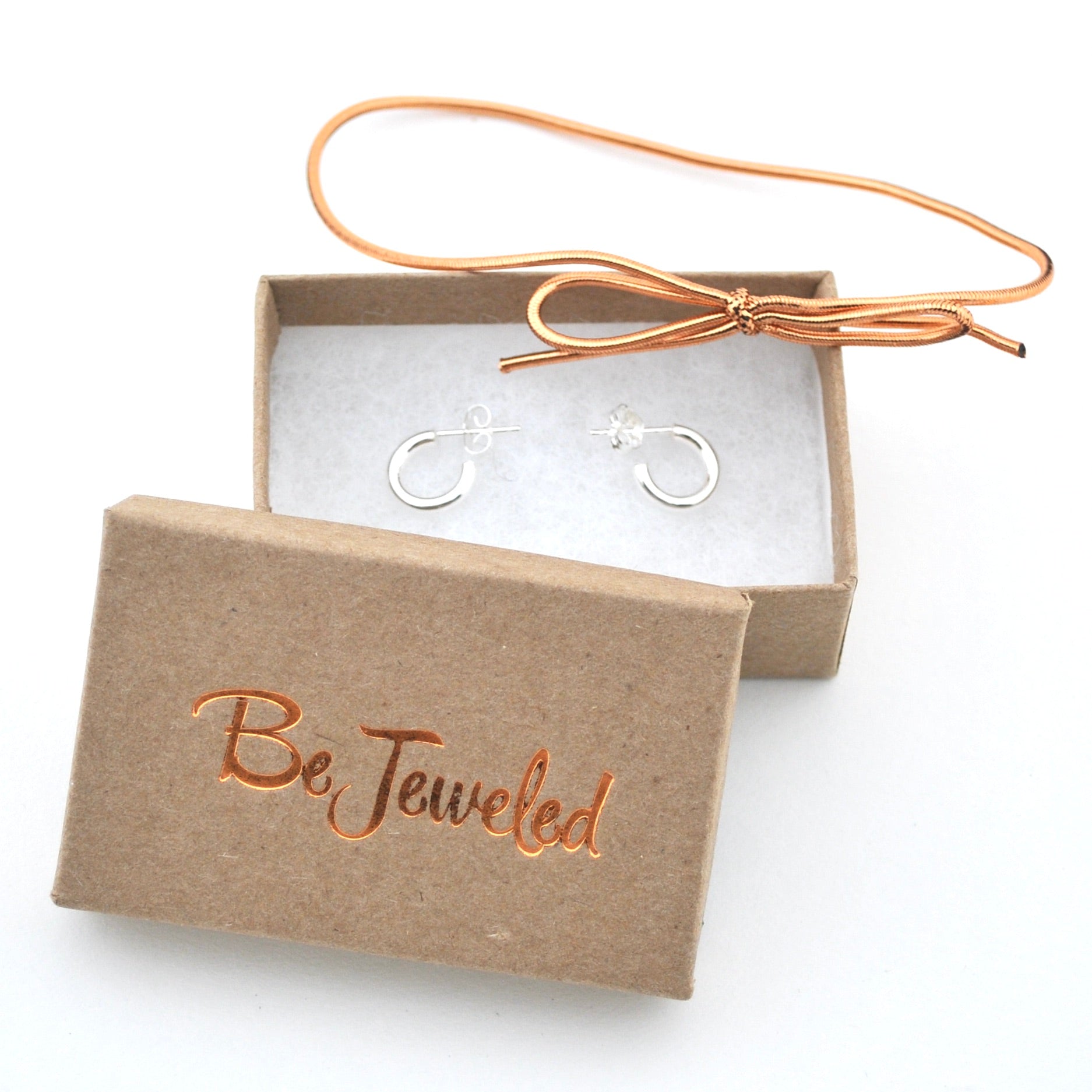Gold hoop earrings in a 'Be Jeweled' box on a white background